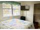 Simple bedroom with a queen-sized bed, TV, and view from window at 425 Highland Ct, Dunedin, FL 34698