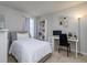 Well-lit bedroom with desk, shelves, and neutral color palette at 4272 Cloud Hopper Way, Lutz, FL 33559