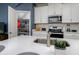 Well-equipped kitchen with a walk-in pantry, modern appliances, white cabinets and a large center island at 4272 Cloud Hopper Way, Lutz, FL 33559