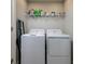 Functional laundry room equipped with washer, dryer, and storage shelf at 4272 Cloud Hopper Way, Lutz, FL 33559