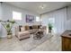 Comfortable living room featuring neutral tones, tile floors, an area rug, and large windows at 4272 Cloud Hopper Way, Lutz, FL 33559