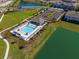 Aerial view of community pool with seating, parking, green space and lake views at 4272 Cloud Hopper Way, Lutz, FL 33559