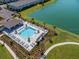 Aerial view of community pool featuring lots of seating, landscaping, and lakeside views at 4272 Cloud Hopper Way, Lutz, FL 33559