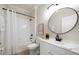 Well-lit bathroom featuring a shower-tub combo, round mirror, and modern vanity for a fresh look at 434 Arch Ridge Loop # 434, Seffner, FL 33584