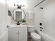 Functional bathroom featuring a combined shower and bathtub, a stylish round mirror, and tiled walls at 434 Arch Ridge Loop # 434, Seffner, FL 33584