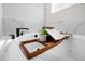 Relaxing bathtub setup with wooden tray, plant, and book, creating a spa-like atmosphere at 434 Arch Ridge Loop # 434, Seffner, FL 33584