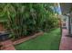 Landscaped backyard with artificial turf, pavers, tropical landscaping, a bench and a trampoline at 436 12Th Ne Ave, St Petersburg, FL 33701