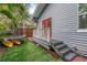 Backyard view of home featuring side porch, orange door, and well maintained lawn at 436 12Th Ne Ave, St Petersburg, FL 33701
