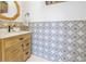 Unique powder room featuring eye-catching patterned tiles on the accent wall, and a light wood vanity with a quartz countertop at 436 12Th Ne Ave, St Petersburg, FL 33701