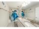 Bright bathroom features a double sink with granite countertop and a shower with a decorative turtle-themed curtain at 4607 Ballantrae Boulevard, Land O Lakes, FL 34638