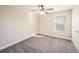 Neutral bedroom has carpeted floors, a ceiling fan and a window providing lots of natural light at 4607 Ballantrae Boulevard, Land O Lakes, FL 34638
