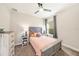 Cozy bedroom with wood-look flooring, a ceiling fan, neutral paint, and natural light from the side window at 4607 Ballantrae Boulevard, Land O Lakes, FL 34638