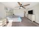 Bedroom with bed, grey carpet, dresser, tv, and windows for ample natural light at 4607 Ballantrae Boulevard, Land O Lakes, FL 34638