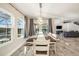 Well-lit dining room featuring an oversized table with seating for six, three large windows, and access to the living room at 4607 Ballantrae Boulevard, Land O Lakes, FL 34638