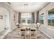 Well-lit dining room featuring an oversized table with seating for six, three large windows, and access to the kitchen at 4607 Ballantrae Boulevard, Land O Lakes, FL 34638