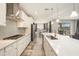 Bright kitchen featuring white cabinets, subway tile backsplash, stainless steel appliances, and a long island with quartz countertop at 4607 Ballantrae Boulevard, Land O Lakes, FL 34638