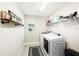 Well-lit laundry room with modern washer and dryer and convenient shelving for storage at 4607 Ballantrae Boulevard, Land O Lakes, FL 34638