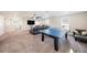 Large carpeted living room with ping pong table, grey couch, tv, and windows providing natural light at 4607 Ballantrae Boulevard, Land O Lakes, FL 34638