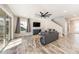 Bright living room with wood-look tile flooring, gray sofa, and large glass sliding door at 4607 Ballantrae Boulevard, Land O Lakes, FL 34638