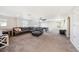 Spacious carpeted living room with brown sectional couch, ping pong table, and natural light from three windows at 4607 Ballantrae Boulevard, Land O Lakes, FL 34638