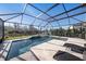 Relaxing screened-in pool area with sun loungers and a tranquil view of the adjacent pond at 4607 Ballantrae Boulevard, Land O Lakes, FL 34638