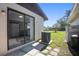 View of the backyard with lawn, patio, air conditioner, and view of the kitchen through sliding door at 4726 Grove Point Dr, Tampa, FL 33624