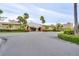 Community clubhouse featuring manicured landscaping, palm trees, and well-maintained asphalt at 4750 Cove Cir # 706, St Petersburg, FL 33708