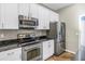 Kitchen showcasing stainless steel appliances, granite counters, white cabinets, and wood-look flooring at 4804 Patagonia Pl, Land O Lakes, FL 34638