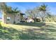Expansive backyard featuring a lush lawn, mature trees, patio seating, and scenic views at 5843 Justicia Loop, Land O Lakes, FL 34639