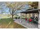 Backyard with a patio, gazebo, seating, and mature tree next to a peaceful pond at 5843 Justicia Loop, Land O Lakes, FL 34639