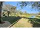 Serene backyard with lush lawn, mature trees, and a peaceful pond view, ideal for relaxation and outdoor enjoyment at 5843 Justicia Loop, Land O Lakes, FL 34639