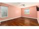 Bedroom with hardwood floors, natural light from two windows, and a ceiling fan at 5843 Justicia Loop, Land O Lakes, FL 34639