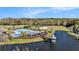 Aerial view of the community pool, beach volleyball court, cabana, and pond at 5843 Justicia Loop, Land O Lakes, FL 34639