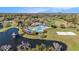 Aerial view of a stunning community pool, tennis courts, beach volleyball, and scenic lake at 5843 Justicia Loop, Land O Lakes, FL 34639