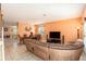 Spacious living room flowing into the dining area, featuring tile flooring and a large comfy sectional at 5843 Justicia Loop, Land O Lakes, FL 34639
