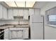 A bright kitchen with white cabinets, granite counters, and modern appliances at 5850 21St N St # 18, St Petersburg, FL 33714