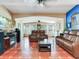 A spacious living room features comfortable brown leather seating, a fireplace, and ample natural light at 6433 Flamingo S Way, St Petersburg, FL 33707