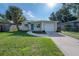 Charming home featuring a well-manicured lawn, complemented by a colorful door and a single-car garage at 6610 S Mascotte St, Tampa, FL 33616