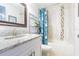 Bathroom featuring a single sink vanity and shower-tub combo with decorative tiling at 822 E Mcewen Ave, Tampa, FL 33612