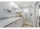 Bright bathroom featuring white cabinetry, granite vanity, and a glass-enclosed shower at 822 E Mcewen Ave, Tampa, FL 33612