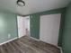 This is a bedroom with wood floors, a closet, and a door leading to another room at 1012 Greenleaf Way, Tarpon Springs, FL 34689