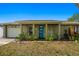 Inviting single-story home featuring a brick facade and a striking blue front door at 1012 Greenleaf Way, Tarpon Springs, FL 34689