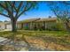 Charming single-story home with a large tree providing shade and a well-maintained lawn at 1012 Greenleaf Way, Tarpon Springs, FL 34689