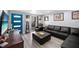 Comfortable living room with a large leather sectional sofa, wood-look flooring, and natural light at 1012 Greenleaf Way, Tarpon Springs, FL 34689