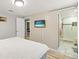 Main bedroom featuring a TV, a bathroom with glass shower doors, and an ensuite bathroom at 1012 Greenleaf Way, Tarpon Springs, FL 34689