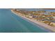 Beautiful aerial view of a beachfront community with pristine sandy beach, modern condos, and clear blue waters at 111 22Nd St, Belleair Beach, FL 33786