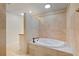 Bathroom with soaking tub and shower featuring a beige tile surround at 111 22Nd St, Belleair Beach, FL 33786