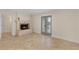 Living room with a stone fireplace, tan tiled floors, and French doors to the backyard at 111 22Nd St, Belleair Beach, FL 33786