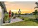 Spacious backyard with a brick patio, fire pit, lush lawn, white fence, and tropical landscaping, ideal for outdoor living at 11605 Cleyera Ct, Riverview, FL 33579