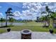 A backyard with a fire pit, a pond view and a well maintained lawn at 11605 Cleyera Ct, Riverview, FL 33579